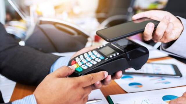 an image of a payment terminal with someone paying with their mobile wallet