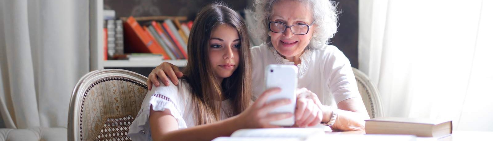 girl and elderly lady viewing mobile phone