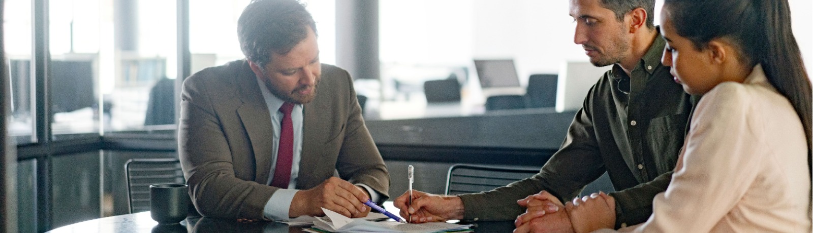 three people looking through a contract agreement