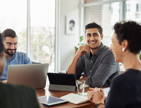 Business partners sitting in a conference room having light conversation.