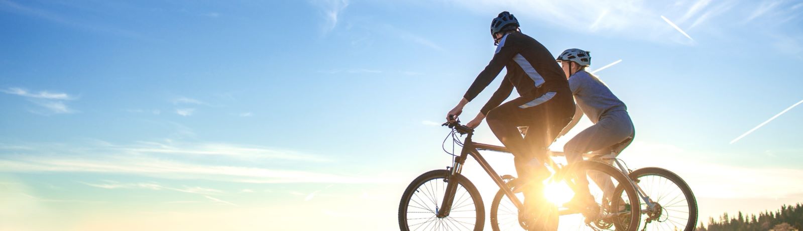 couple riding bicycles at sunset