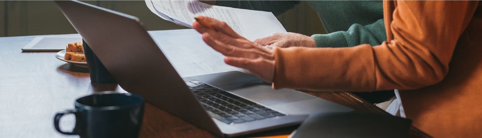 A laptop sitting on a desk with a persons hand looking like they are going to type something